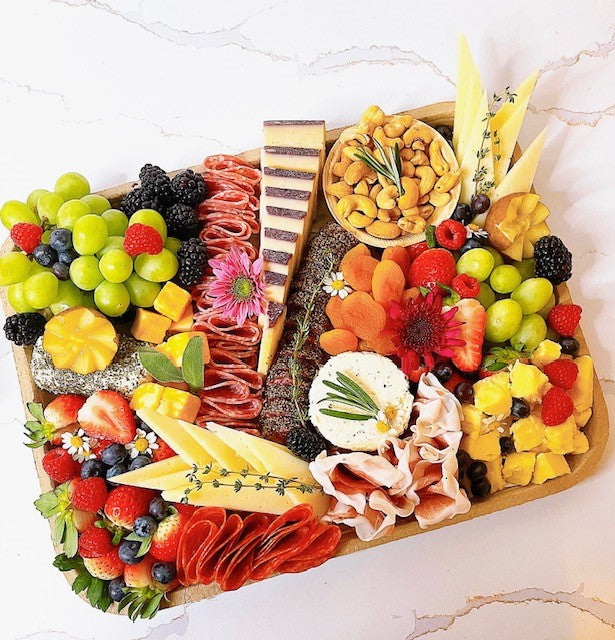Gourmet charcuterie board with artisanal cheeses, cured meats, fruits, and nuts